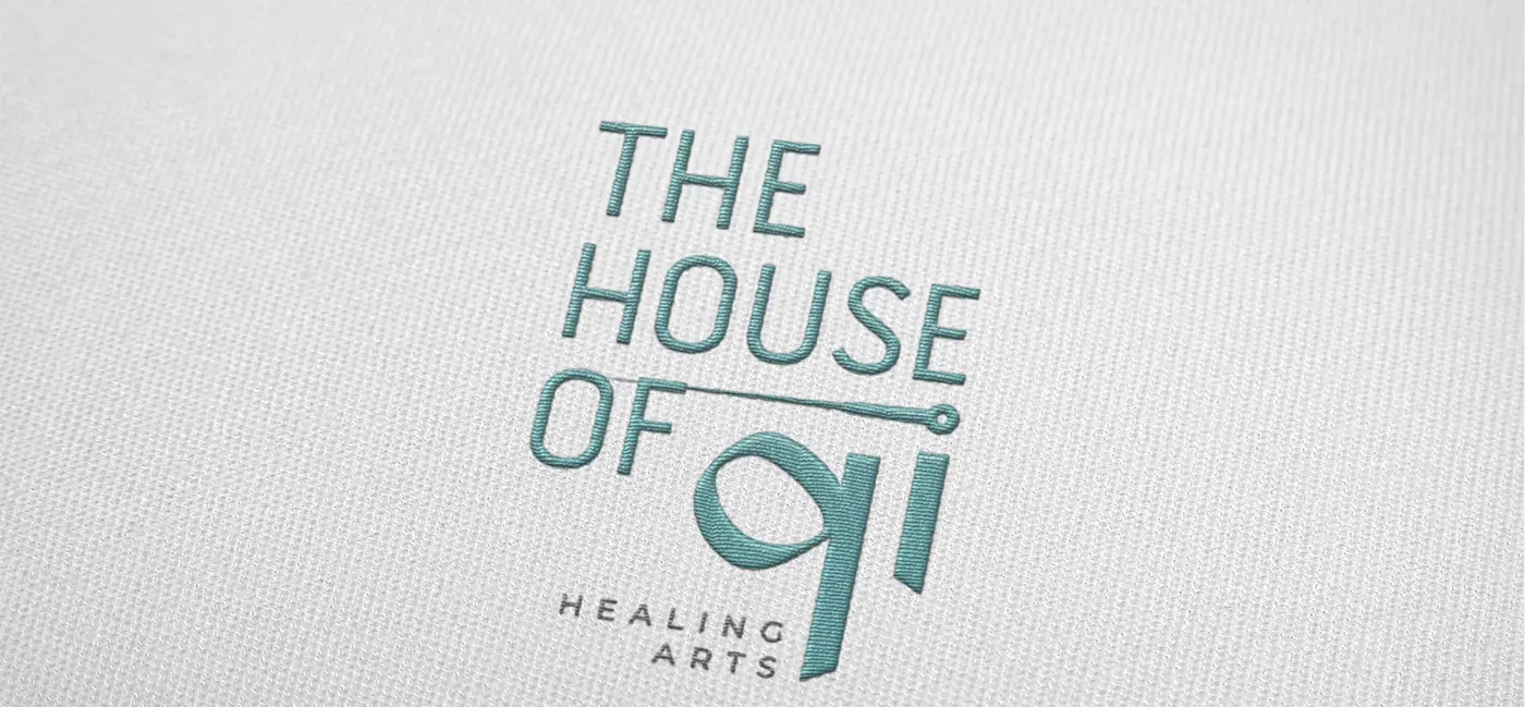 Logotipo bordado en hilo turquesa sobre una prenda textil