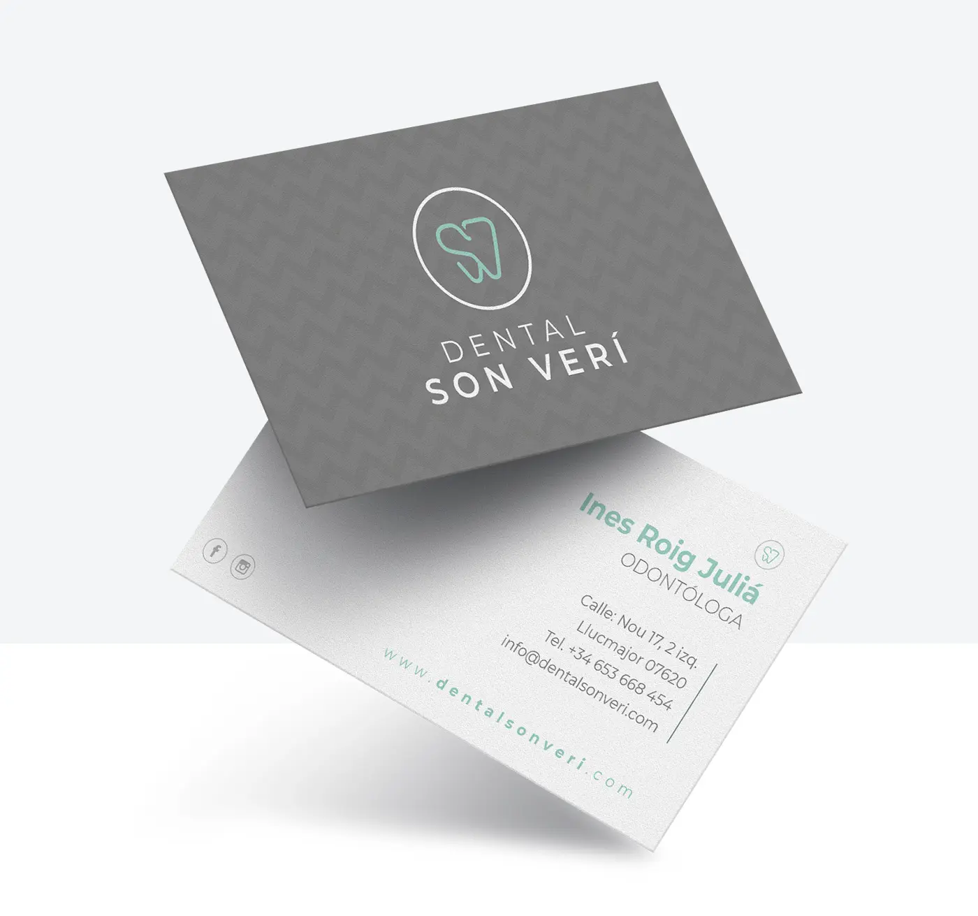 The dentist's business cards with the logo on a textured grey background
