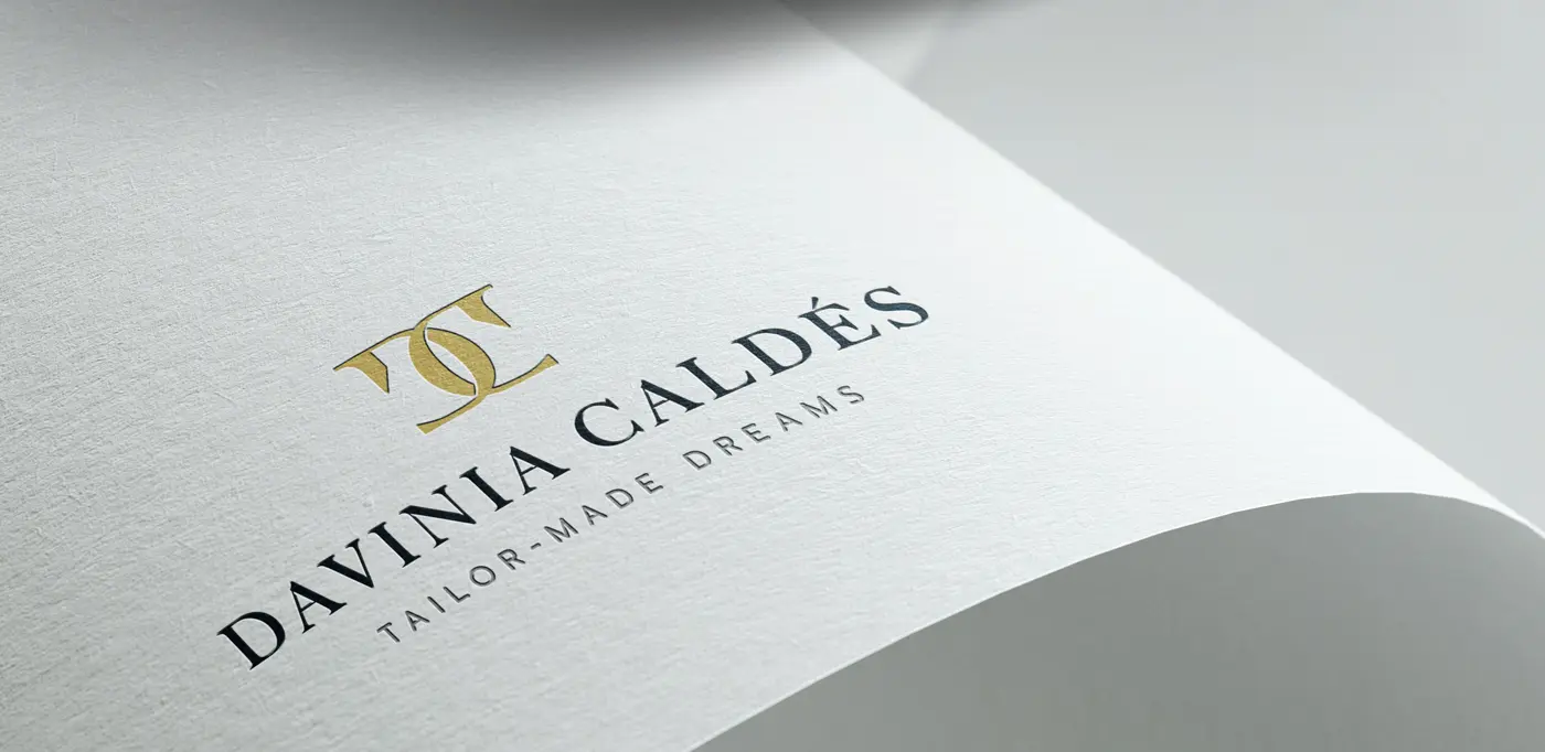 Logotipo grabado en relieve dorado sobre papel texturizado blanco
