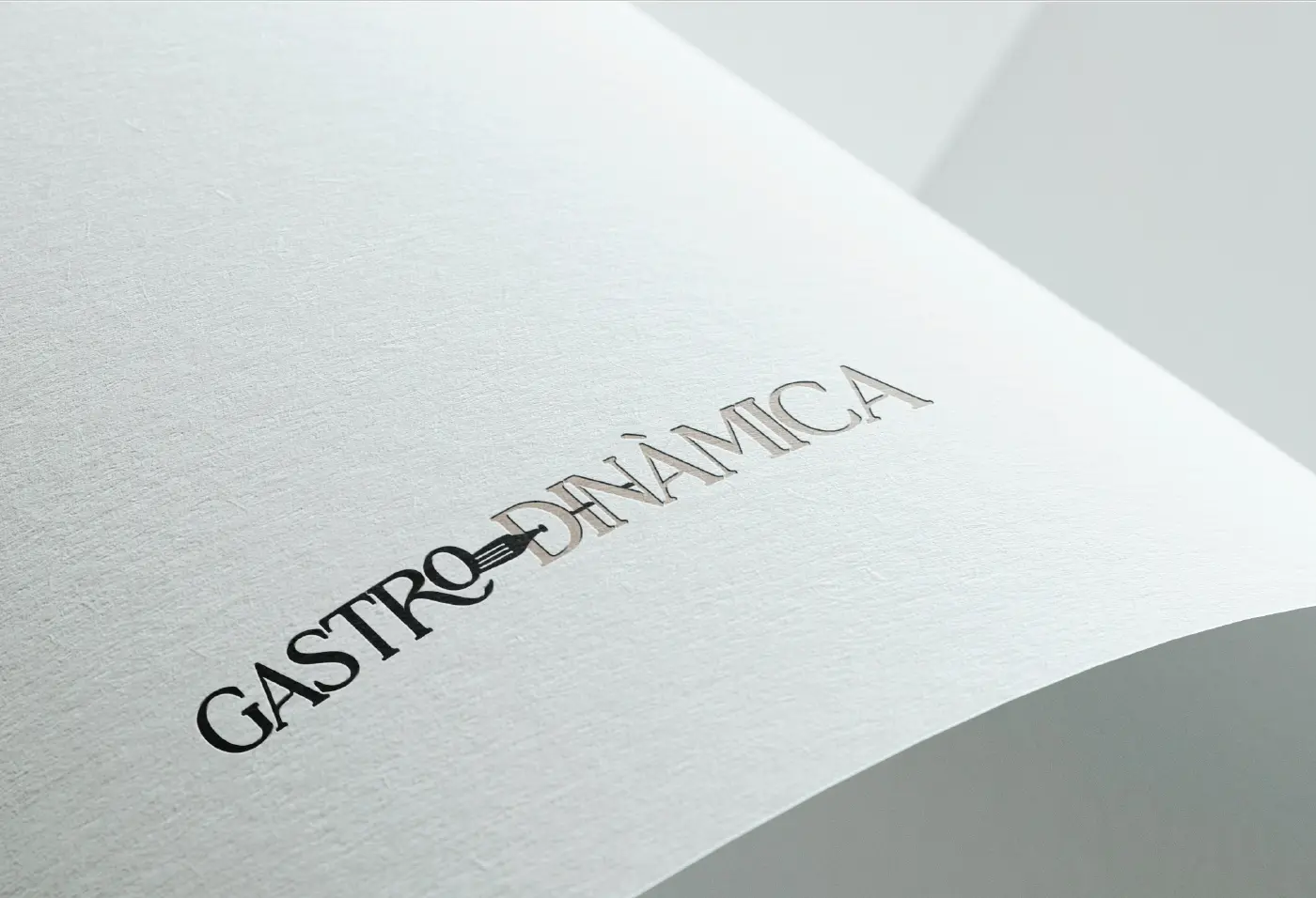Logotipo de Gastrodinàmica grabado en relieve sobre papel texturizado