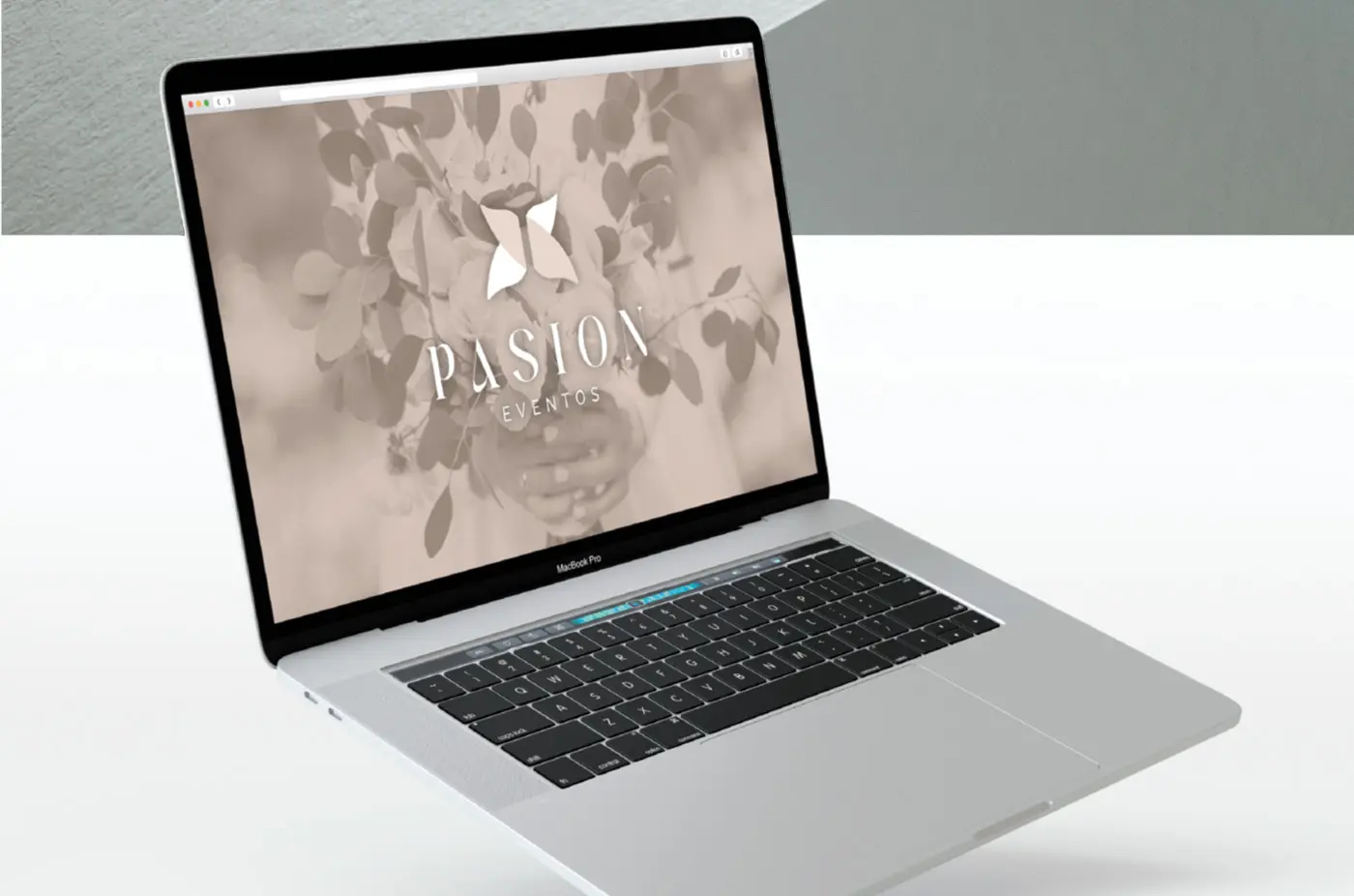 Laptop mockup with the Pasión Eventos website over a floral photograph