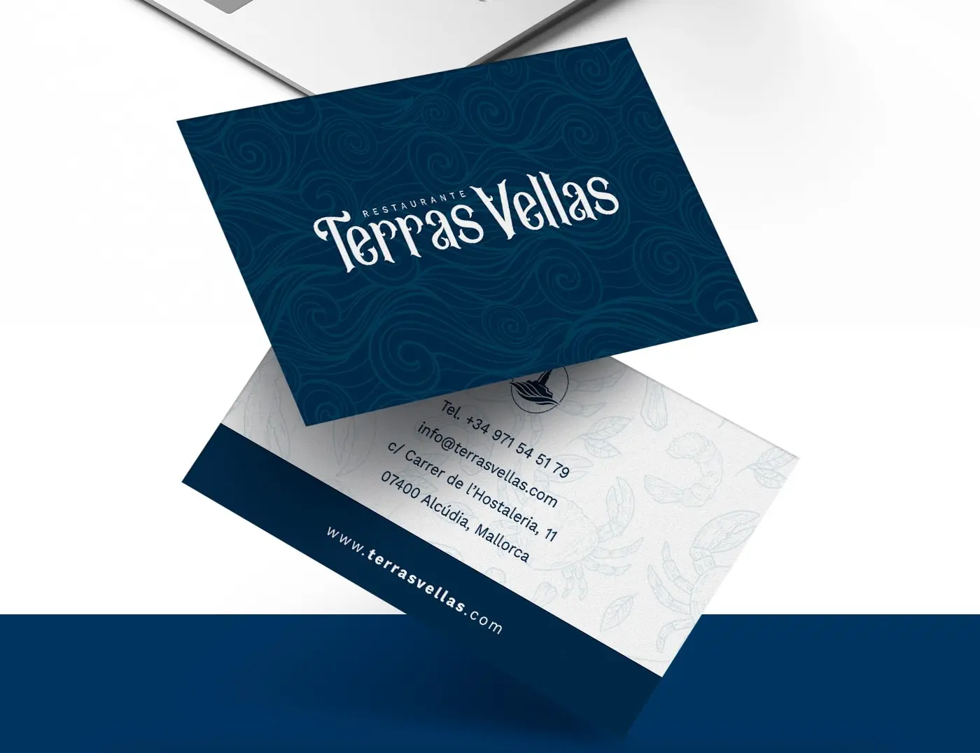 Business cards with the logotype over blue waves and seafood motifs on the back