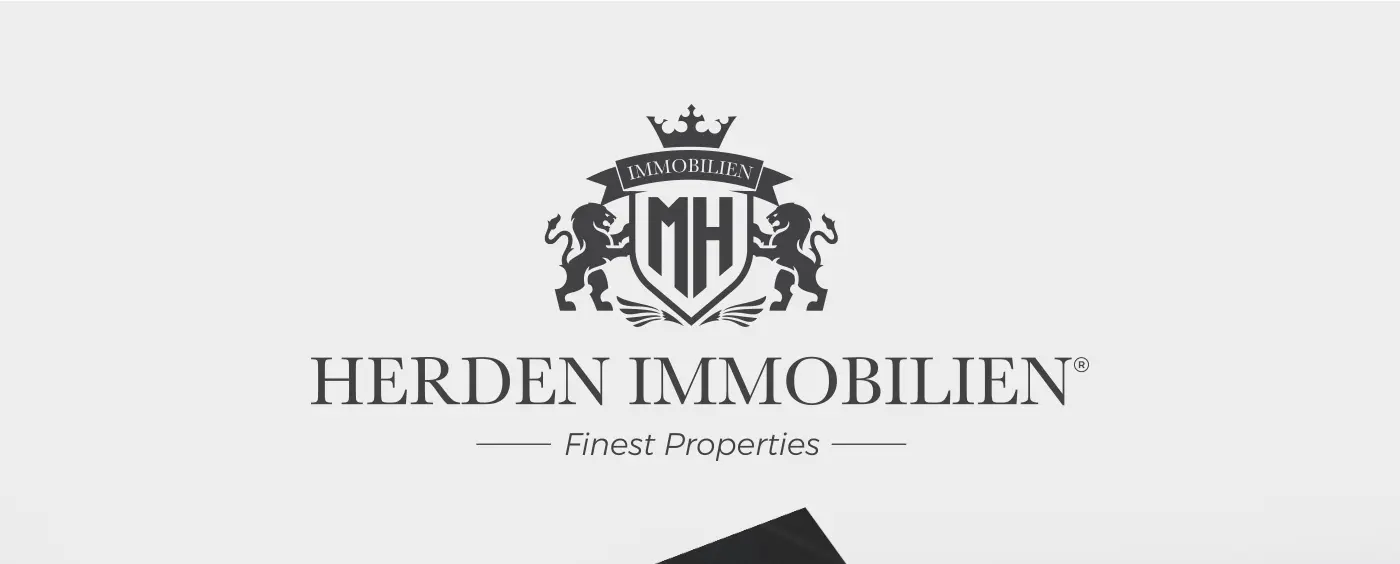 Logotipo de Herden Immobilien con escudo, corona y leones heráldicos en gris oscuro