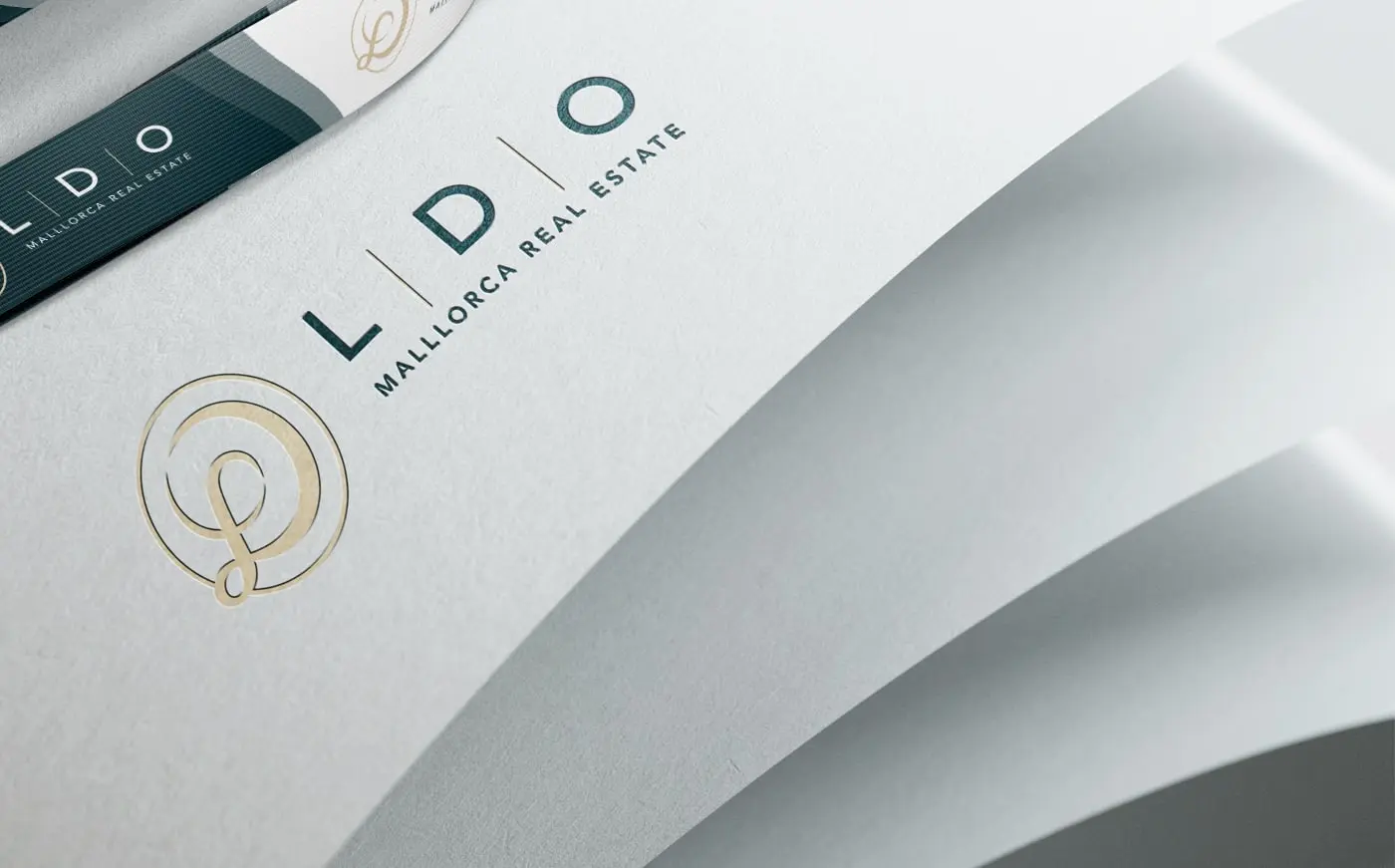 Detalle en relieve del logotipo LDO sobre papel crema plegado
