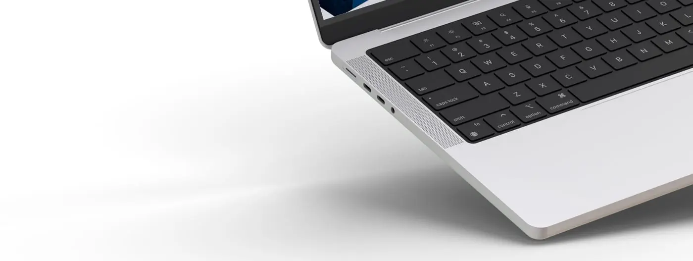 Detalle del lateral y teclado del portátil con la web de fondo