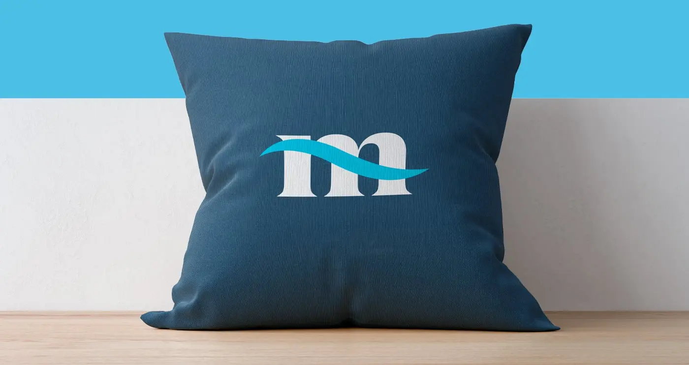 Cojín decorativo azul marino con el isotipo de la ola de Mares Properties