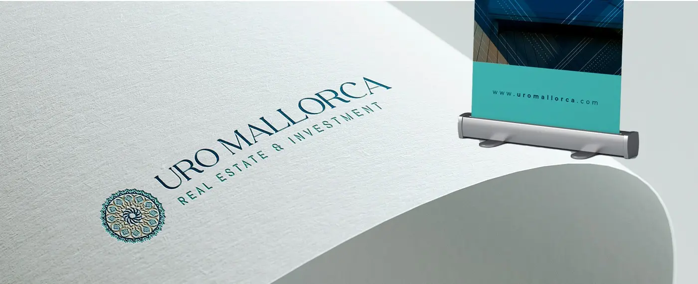 Detail of the logotype with the geometric rose window printed on textured paper next to a roll-up