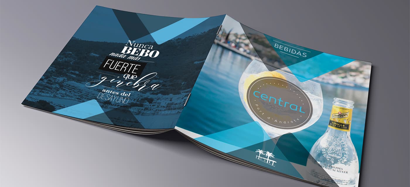 Carta de begudes amb copa de còctel i ampolla de Schweppes al costat del mar