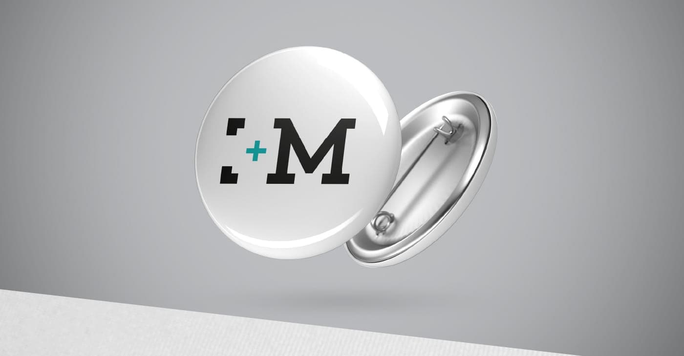 Mockup of a white metal badge with the MVG icon in black and turquoise