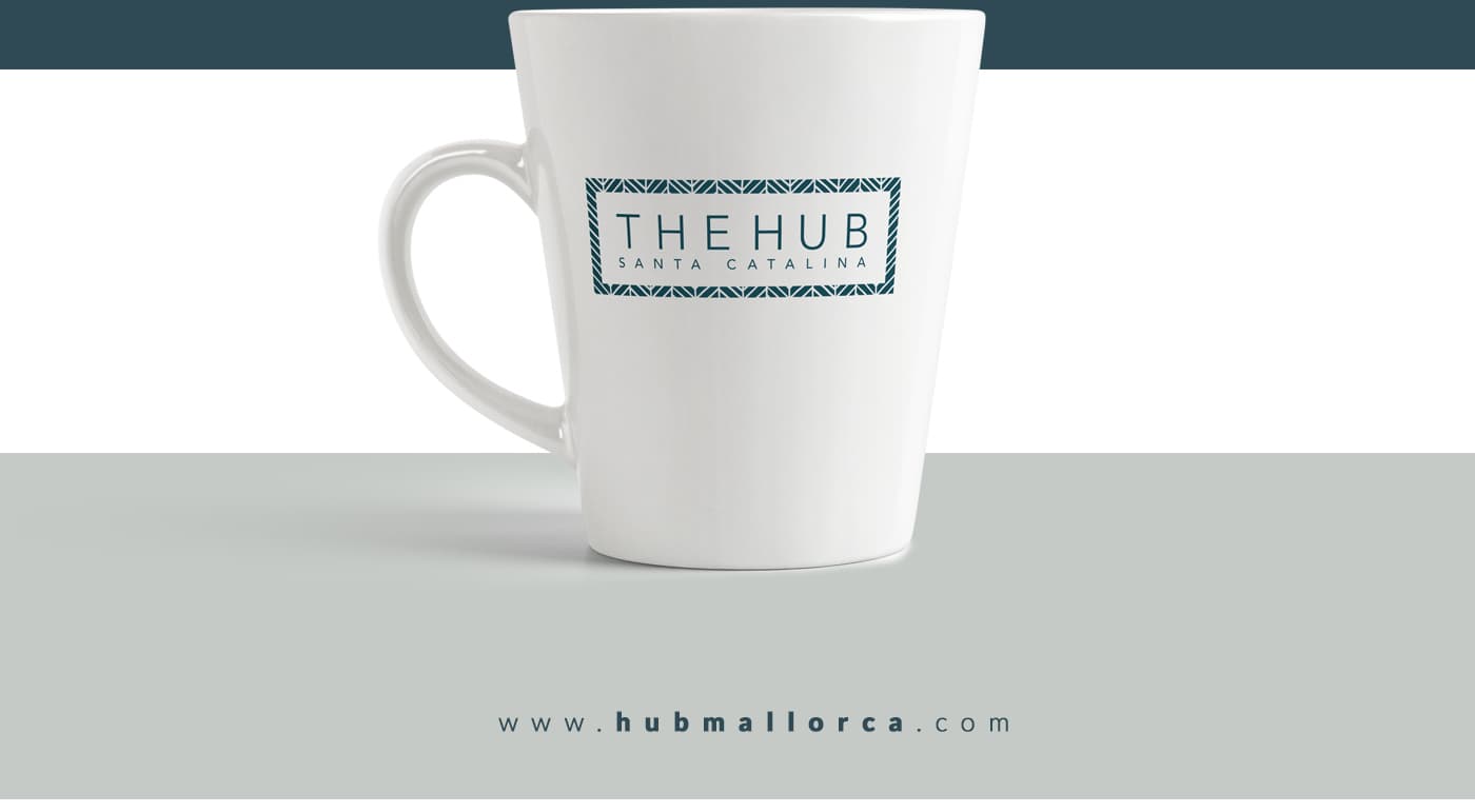 Taza blanca con el logotipo The Hub Santa Catalina en azul petróleo