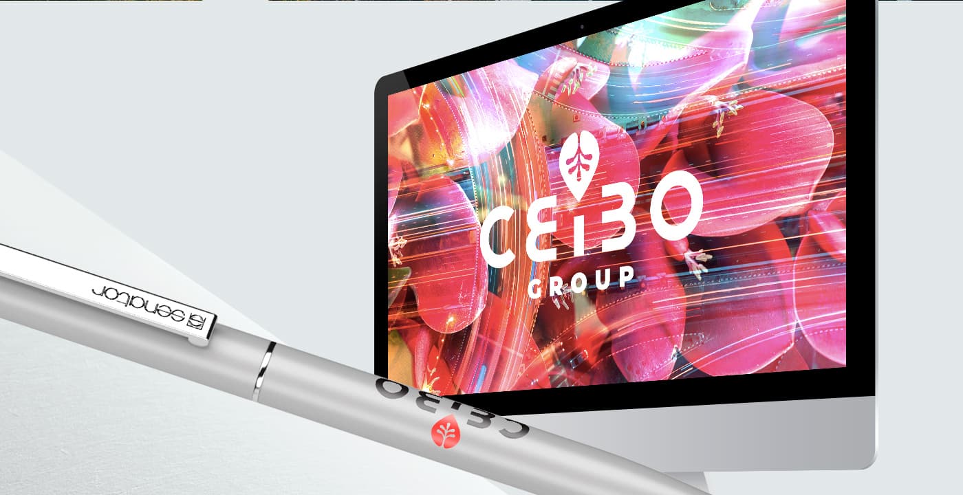 Mockup del logotip de Ceibo Group en pantalla d'ordinador al costat d'un bolígraf corporatiu