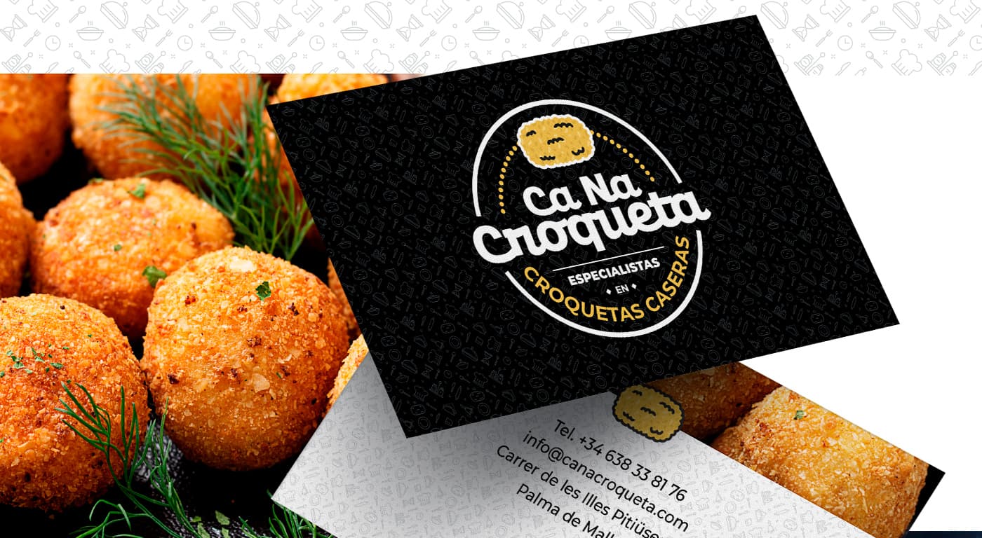 Tarjetas de visita en negro con el logotipo y croquetas doradas de fondo