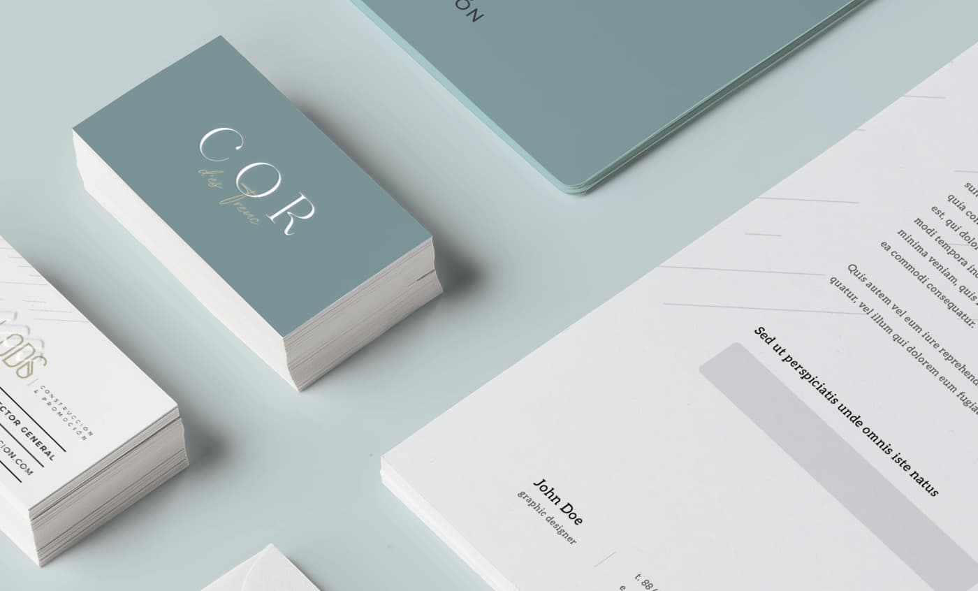Mockup de tarjetas de visita en azul grisáceo y papelería con el logotipo