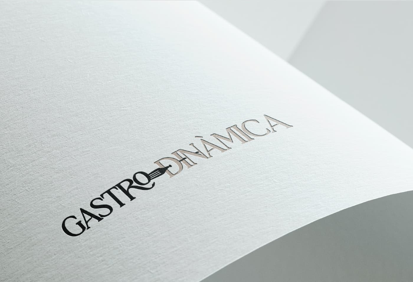 Logotip de Gastrodinàmica gravat en relleu sobre paper texturitzat