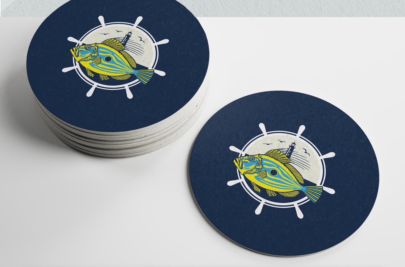 Mockup of navy blue round coasters with the fish and helm isotype