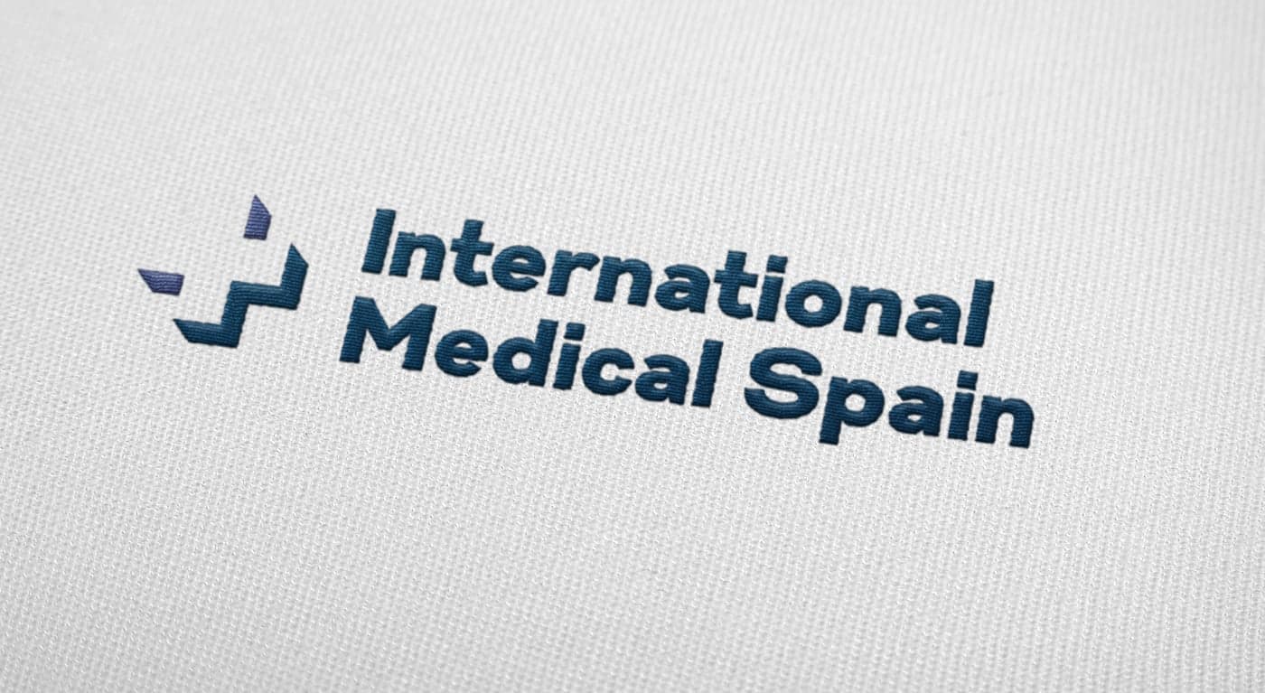 Logo embroidered in navy blue and purple on white fabric as a textile application