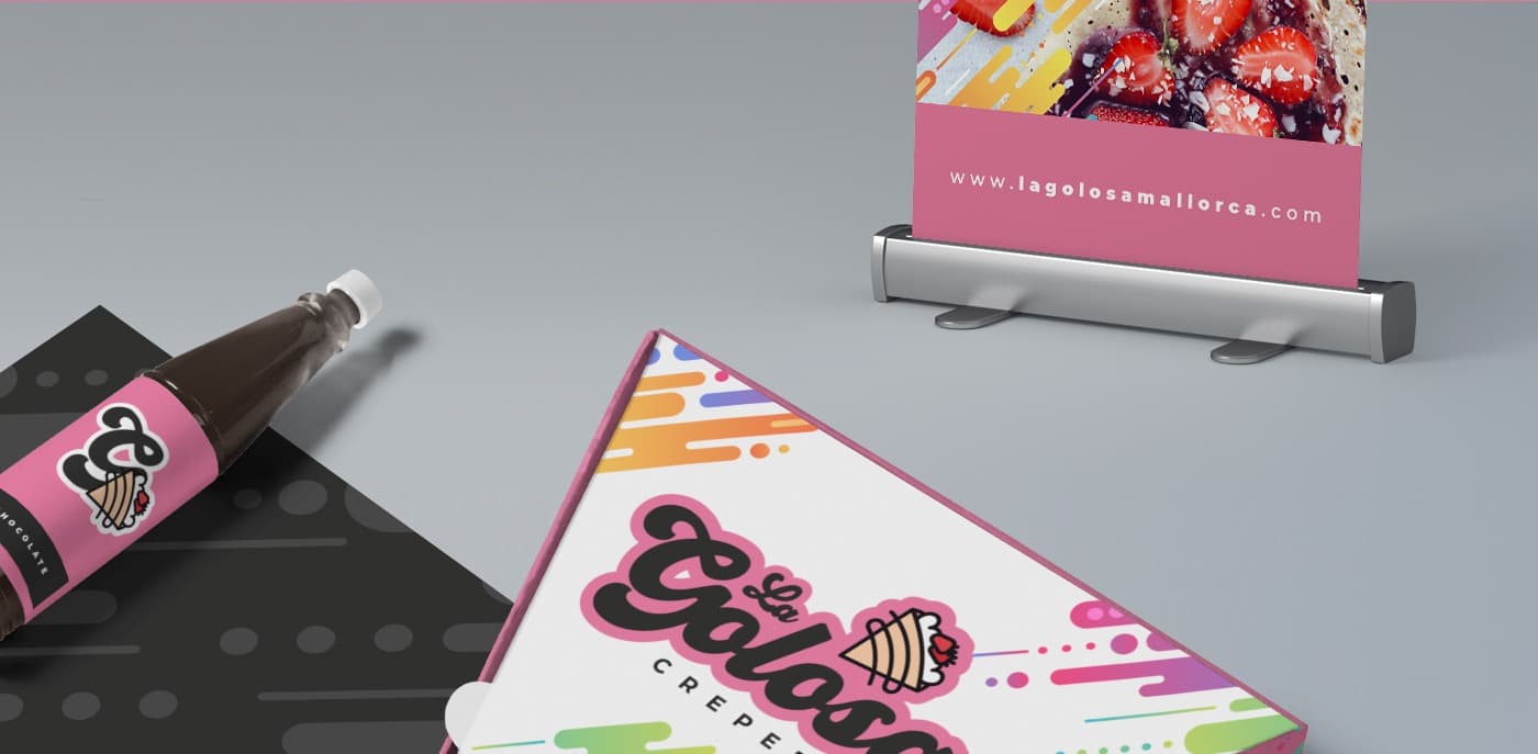 Roll-up, botella de topping de chocolate y caja triangular con el logotipo de La Golosa