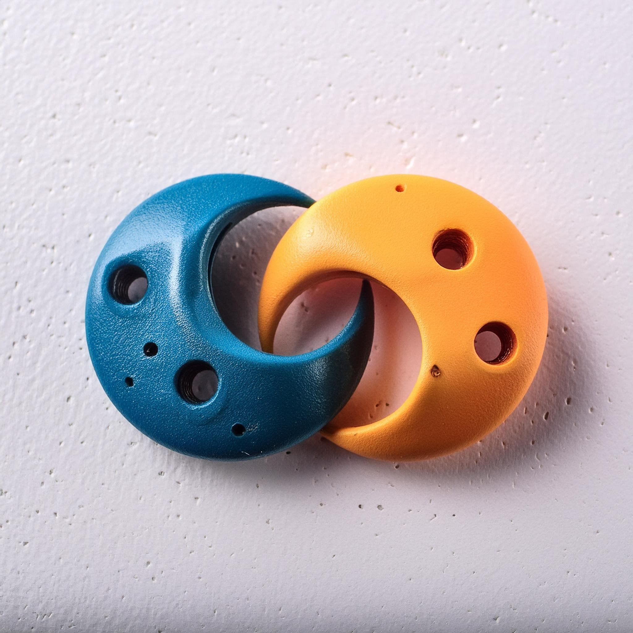 Presas de escalada azul y naranja entrelazadas como el símbolo del logo