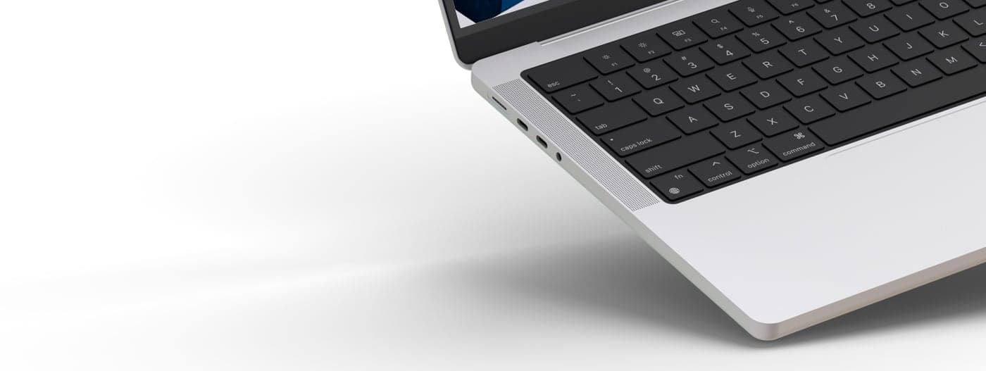 Detalle del lateral y teclado del portátil con la web de fondo