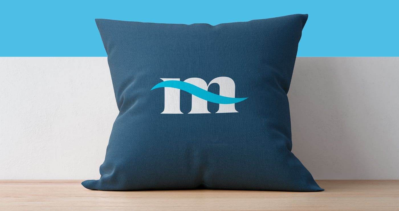 Cojín decorativo azul marino con el isotipo de la ola de Mares Properties