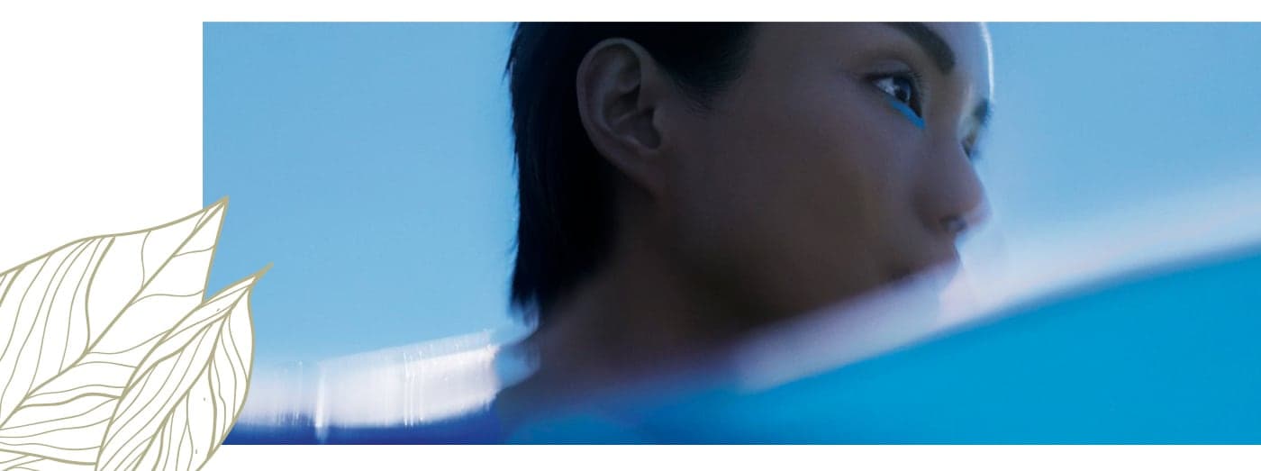 Profile portrait of a model with blue eyeliner and soft-focus light