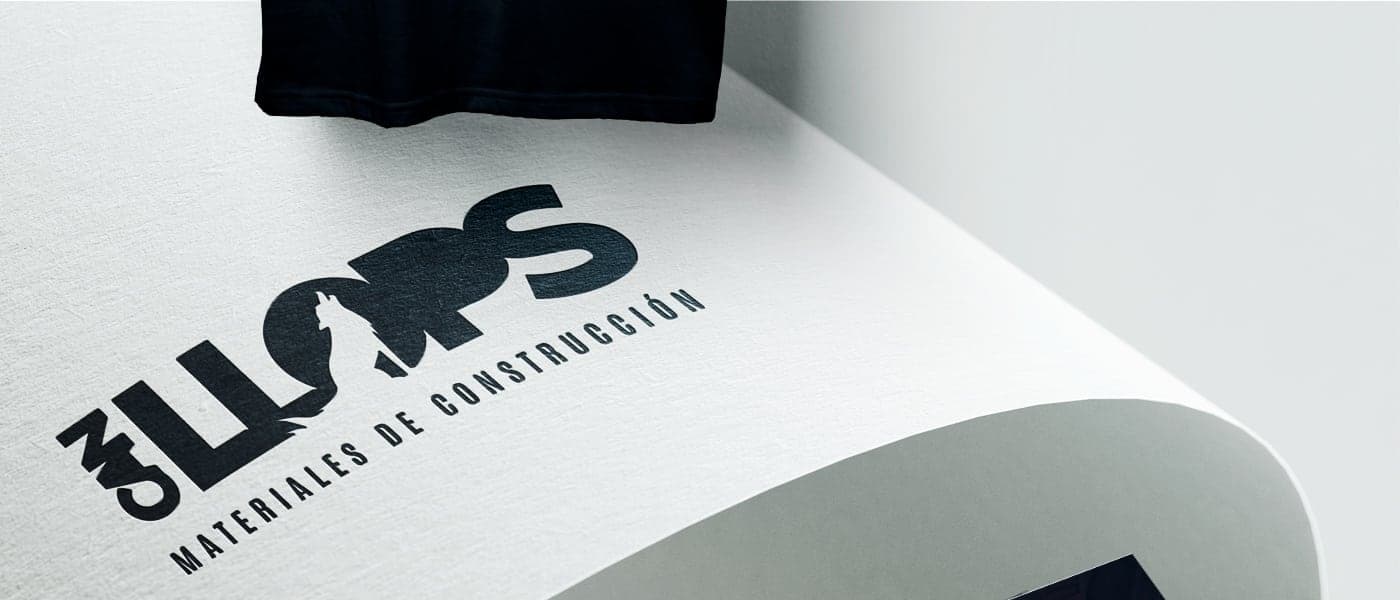 Detall del logotip estampat sobre paper al costat d'un bloc de formigó