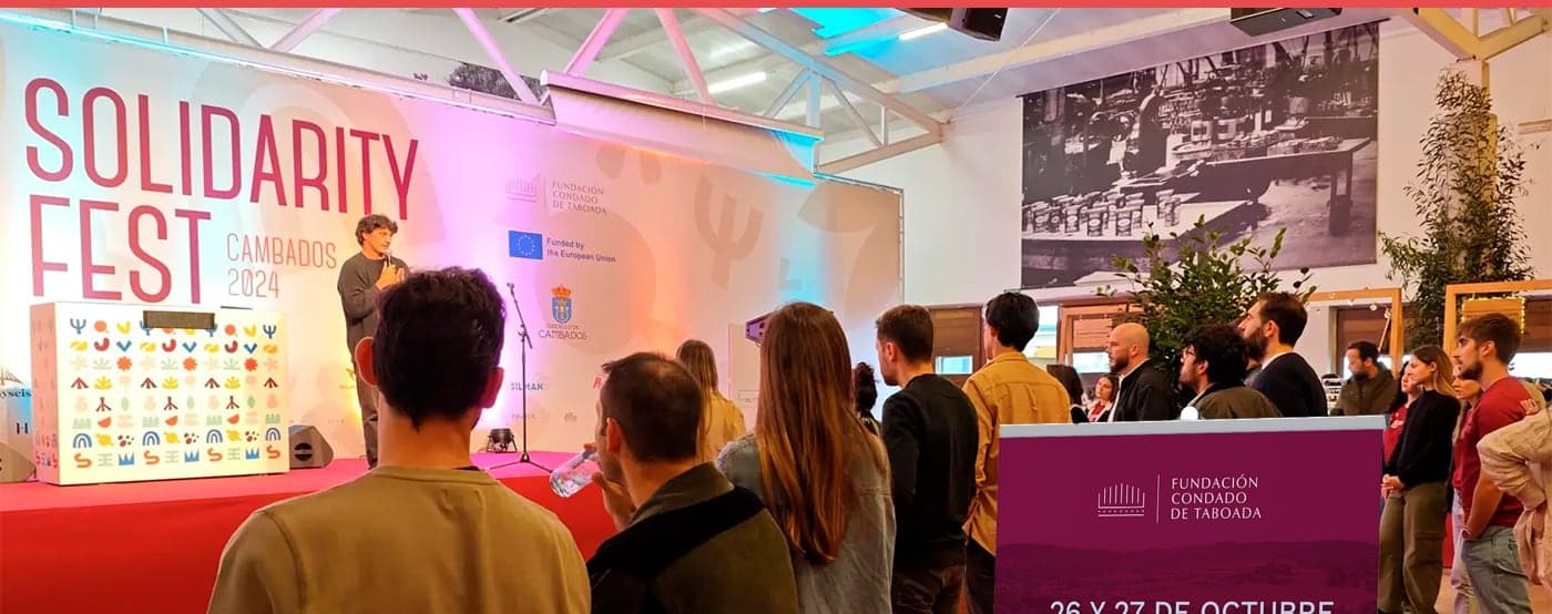 Presentación del evento en un escenario con photocall y público asistente