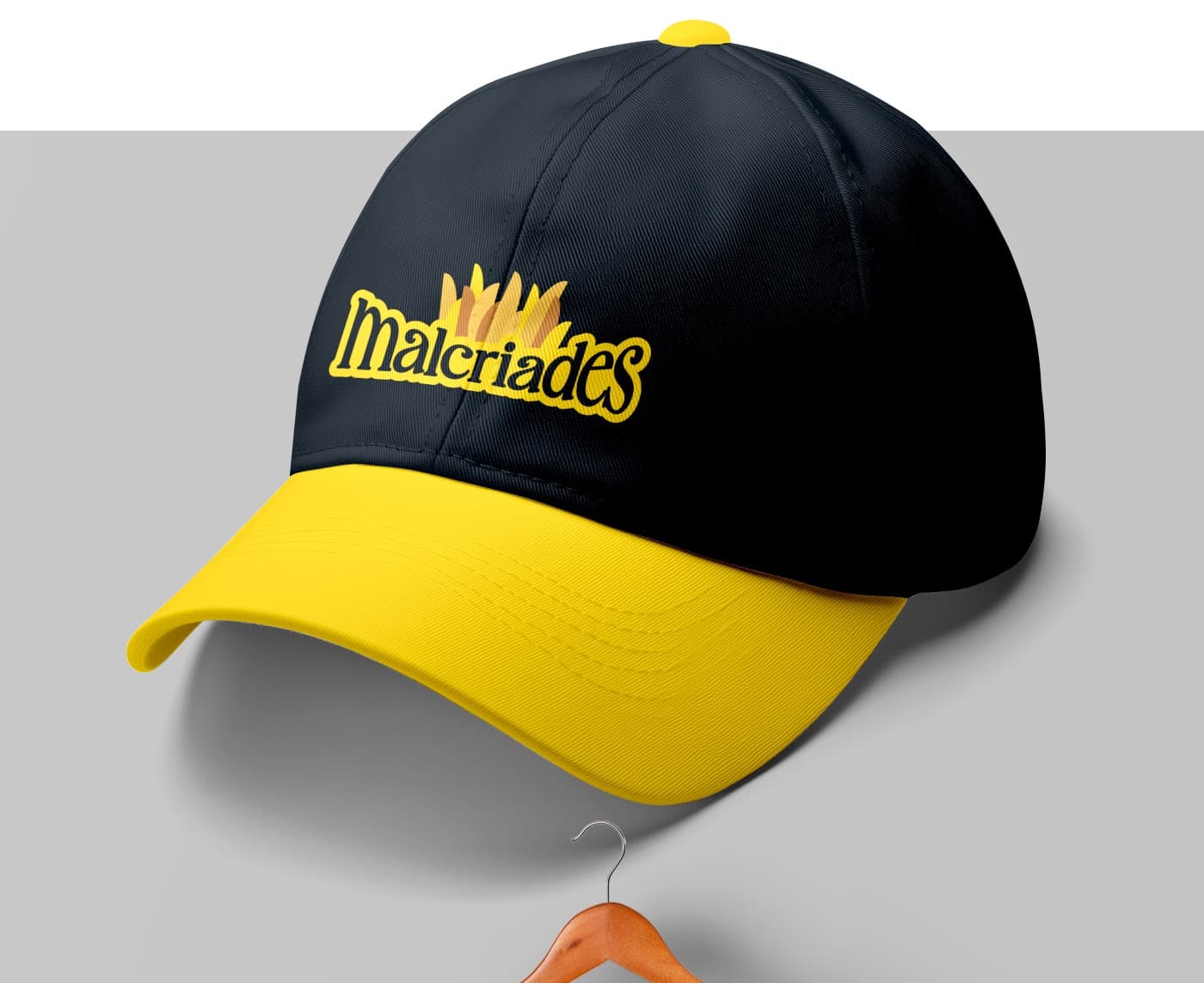 Gorra negra y amarilla bordada con el logotipo completo de Malcriades