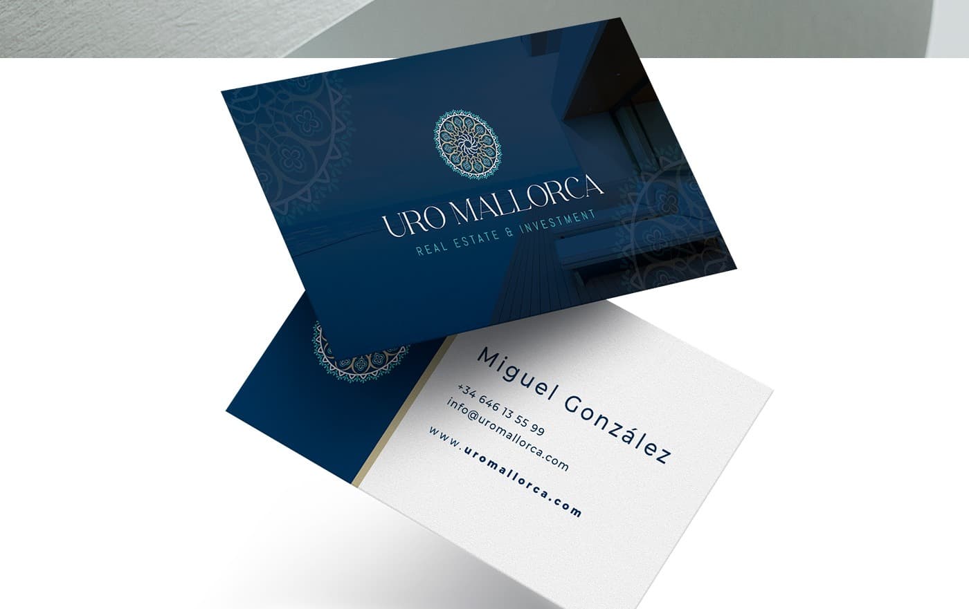 Targetes de visita blau marí amb el logotip sobre una fotografia arquitectònica