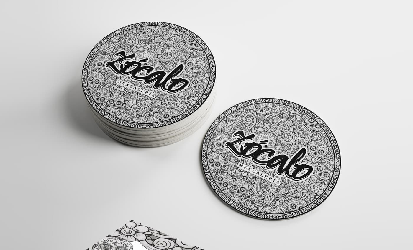 Mockup de posavasos circulars amb il·lustració de calaveres i el logotip de Zócalo